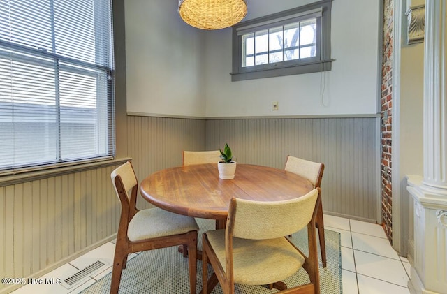 dining space featuring light tile patterned floors and decorative columns