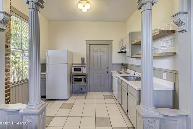 kitchen featuring light tile patterned floors, white appliances, gray cabinets, sink, and ornate columns