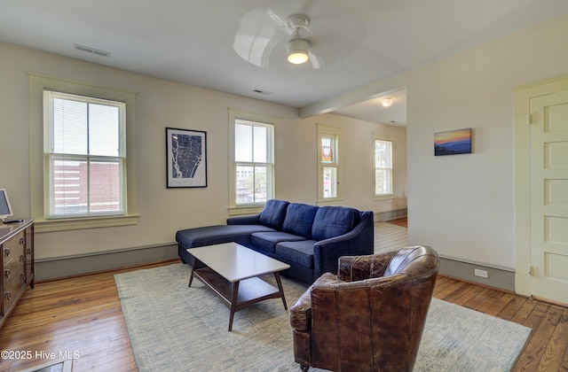 living room featuring light hardwood / wood-style flooring and ceiling fan