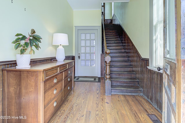 stairs featuring ornamental molding and hardwood / wood-style floors