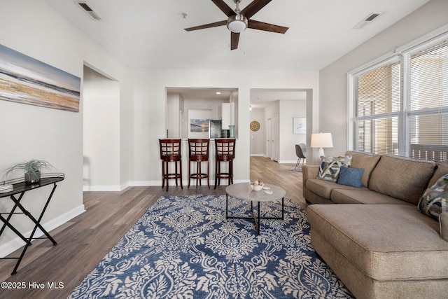 living room with wood-type flooring and ceiling fan