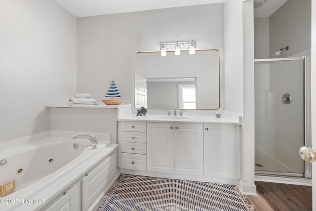 bathroom with hardwood / wood-style flooring, shower with separate bathtub, and vanity