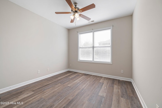 empty room with dark hardwood / wood-style floors and ceiling fan