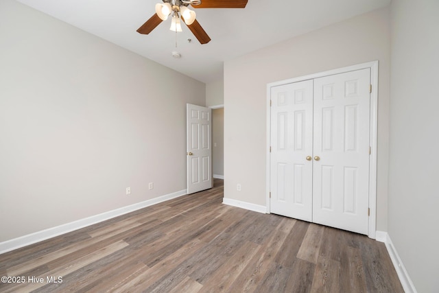 unfurnished bedroom featuring hardwood / wood-style floors, a closet, and ceiling fan