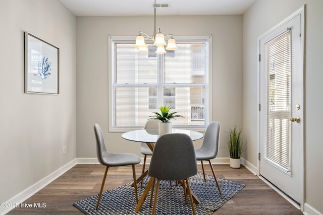 dining area featuring a notable chandelier and dark wood-type flooring