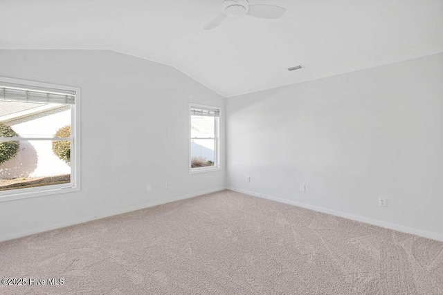 spare room featuring ceiling fan, carpet flooring, and vaulted ceiling