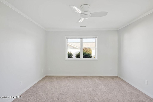 carpeted empty room featuring ceiling fan and crown molding