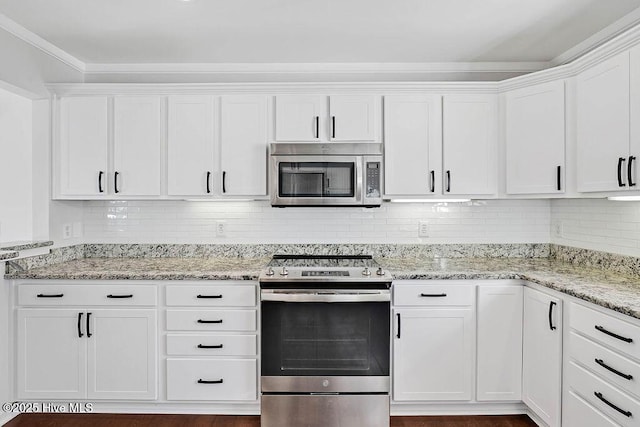 kitchen featuring stainless steel appliances, decorative backsplash, white cabinetry, and light stone countertops