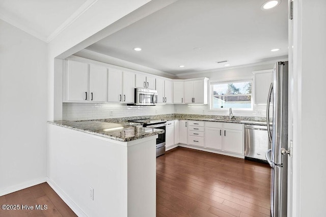 kitchen featuring white cabinets, stainless steel appliances, and kitchen peninsula