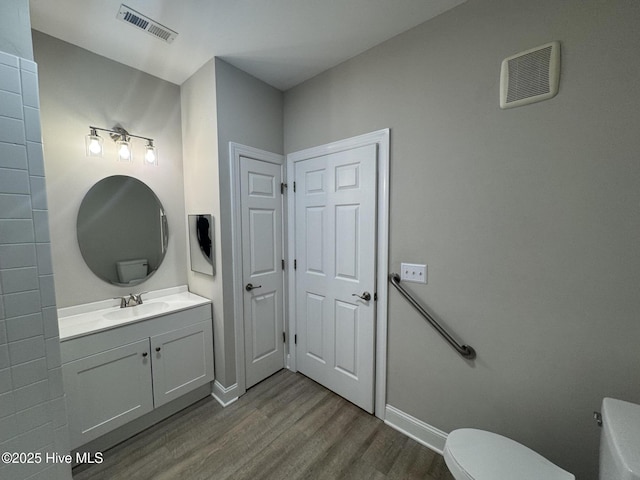 bathroom with vanity, wood-type flooring, and toilet