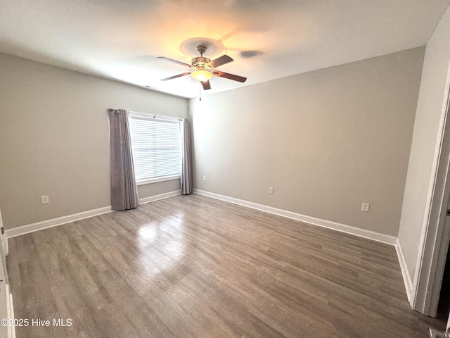 spare room featuring dark wood-type flooring and ceiling fan