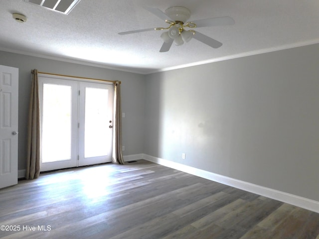 empty room featuring crown molding, wood finished floors, ceiling fan, and baseboards