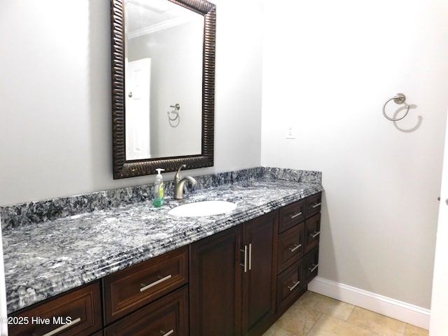 bathroom featuring vanity, baseboards, and ornamental molding