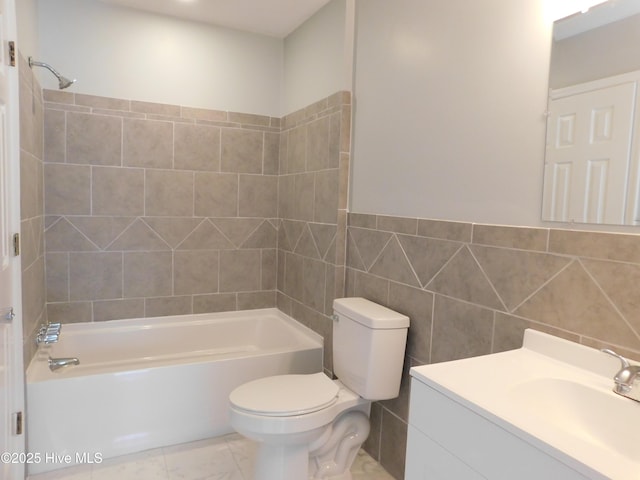bathroom with toilet, shower / bath combination, vanity, and tile walls