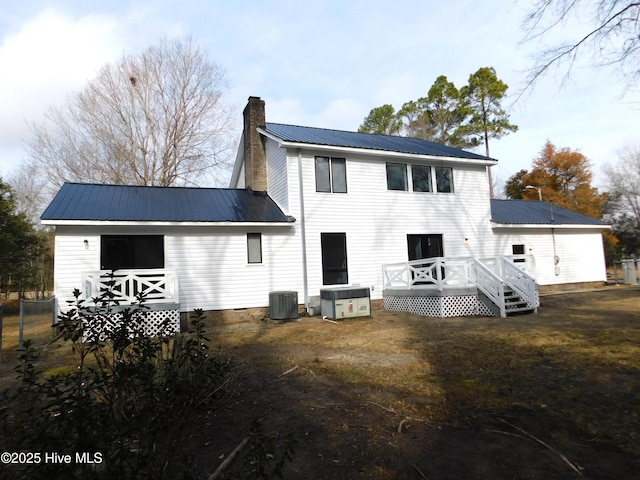 rear view of house with a wooden deck and central AC unit