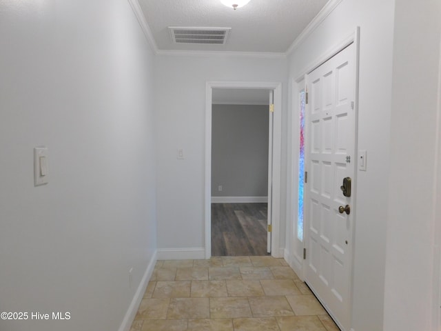 entryway with ornamental molding and a textured ceiling