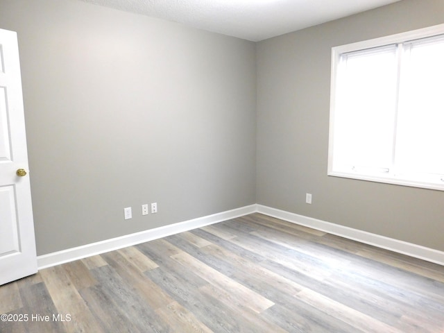 empty room featuring baseboards and wood finished floors