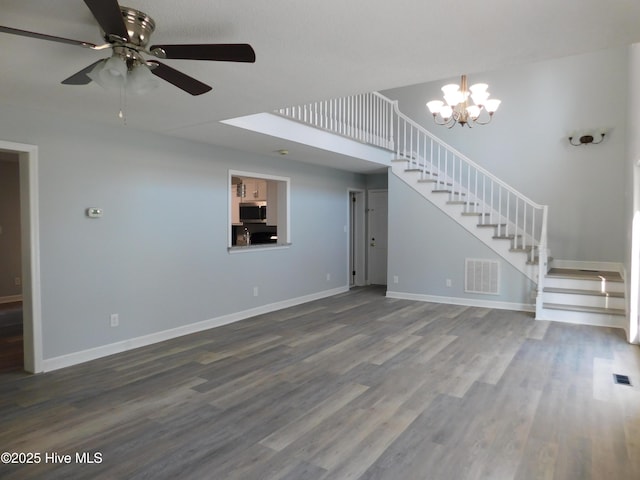 unfurnished living room with ceiling fan with notable chandelier and hardwood / wood-style floors