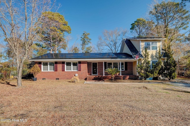 view of front of house with a front lawn and solar panels