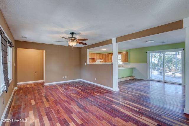 unfurnished living room with hardwood / wood-style flooring, a textured ceiling, and ceiling fan