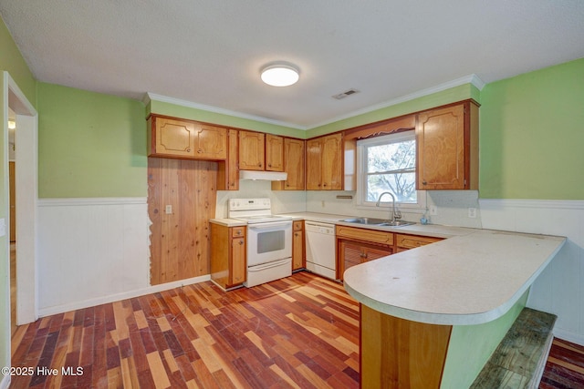 kitchen with sink, white appliances, light hardwood / wood-style flooring, and kitchen peninsula