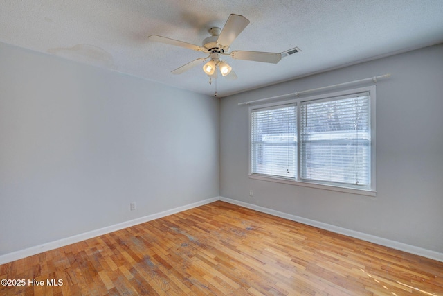 spare room with ceiling fan, a textured ceiling, and light hardwood / wood-style floors