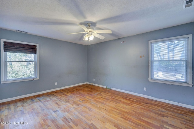 empty room featuring ceiling fan, a textured ceiling, and light hardwood / wood-style flooring