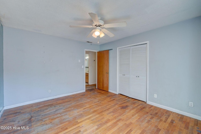 unfurnished bedroom with ceiling fan, light hardwood / wood-style floors, and a closet