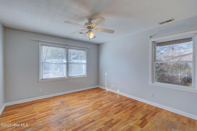 empty room with ceiling fan, a textured ceiling, and light wood-type flooring