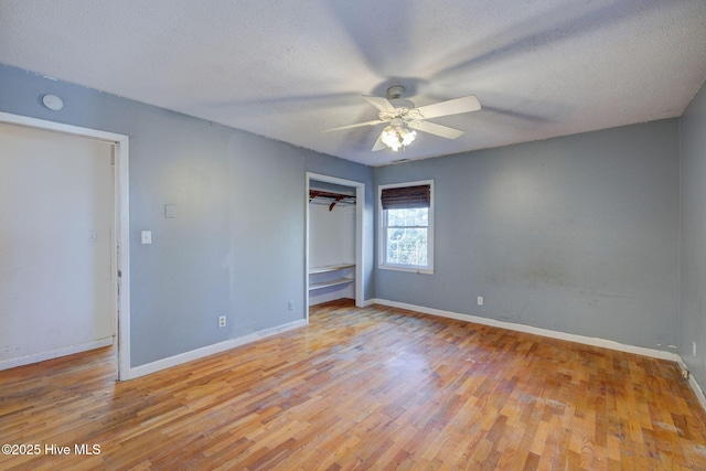 unfurnished bedroom featuring ceiling fan, light hardwood / wood-style flooring, a closet, and a textured ceiling