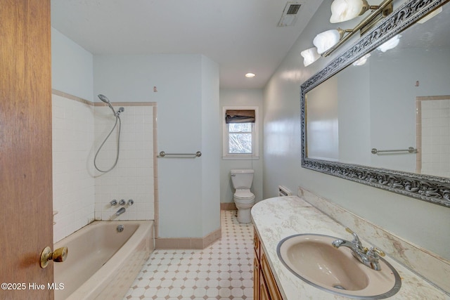 full bathroom with tiled shower / bath combo, vanity, and toilet