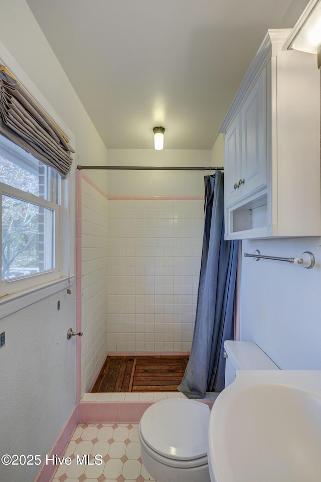 bathroom featuring a shower with curtain, toilet, and sink