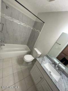 full bathroom featuring vanity, toilet, tiled shower / bath combo, and tile patterned flooring