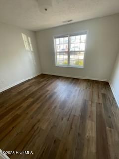 unfurnished room with dark hardwood / wood-style flooring