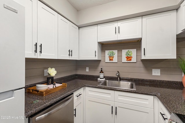 kitchen featuring white cabinetry, stainless steel dishwasher, sink, and white fridge