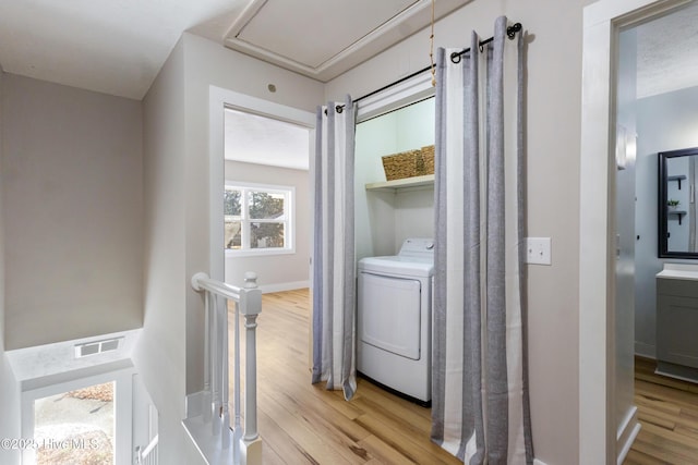 laundry area with washer / clothes dryer and light hardwood / wood-style floors