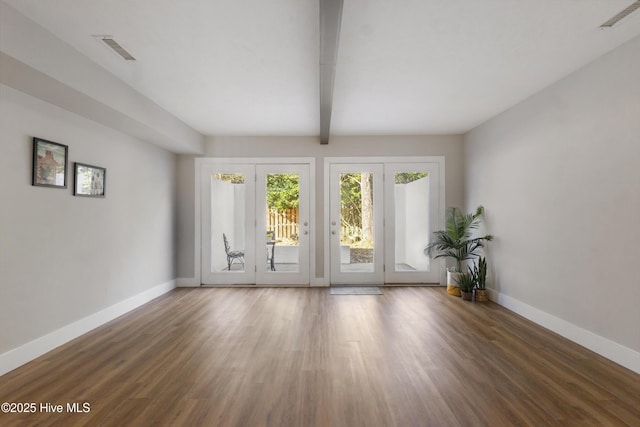 unfurnished room featuring beam ceiling and dark wood-type flooring