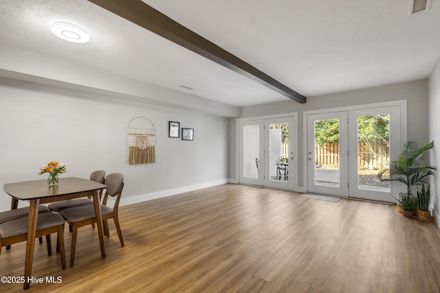 dining space featuring beam ceiling and wood-type flooring