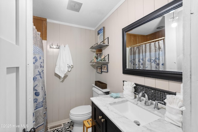 bathroom with vanity, ornamental molding, and toilet