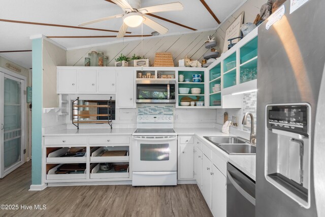 kitchen with light wood finished floors, open shelves, appliances with stainless steel finishes, white cabinets, and a sink