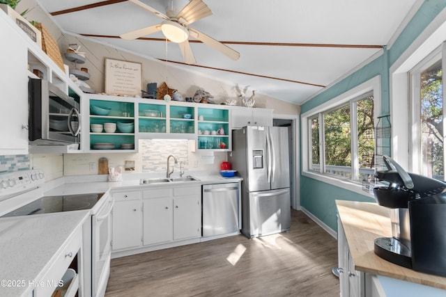 kitchen featuring light wood finished floors, white cabinets, appliances with stainless steel finishes, open shelves, and a sink