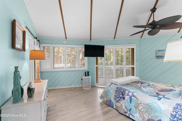 bedroom with light wood-style floors and vaulted ceiling