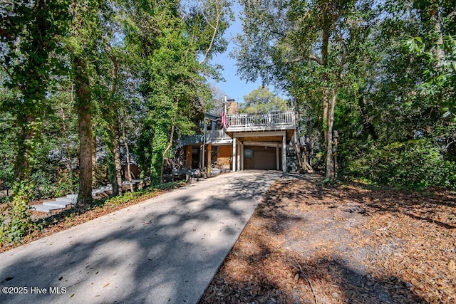 114 White Ash Dr, Pine Knoll Shores, NC 28512 - view of front of property featuring a garage, a chimney, concrete driveway, and a deck