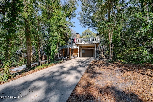 view of front facade featuring a garage, concrete driveway, and a chimney