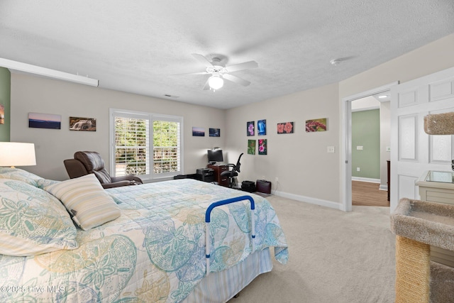 bedroom with light carpet, ceiling fan, and a textured ceiling