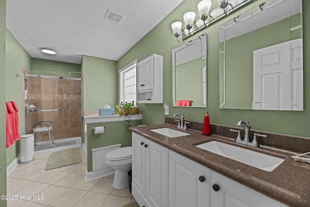 bathroom with walk in shower, tile patterned floors, toilet, a textured ceiling, and vanity