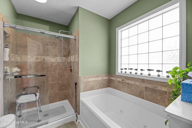 bathroom with shower with separate bathtub and a textured ceiling