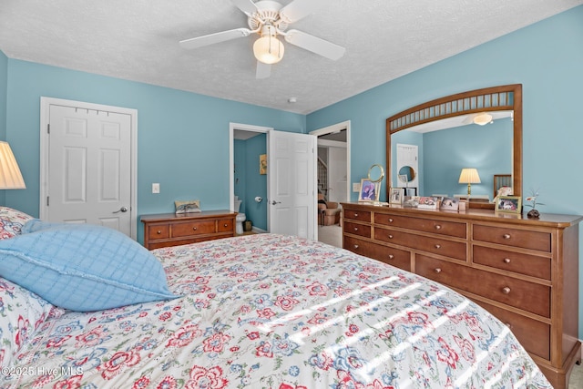 bedroom with ceiling fan and a textured ceiling