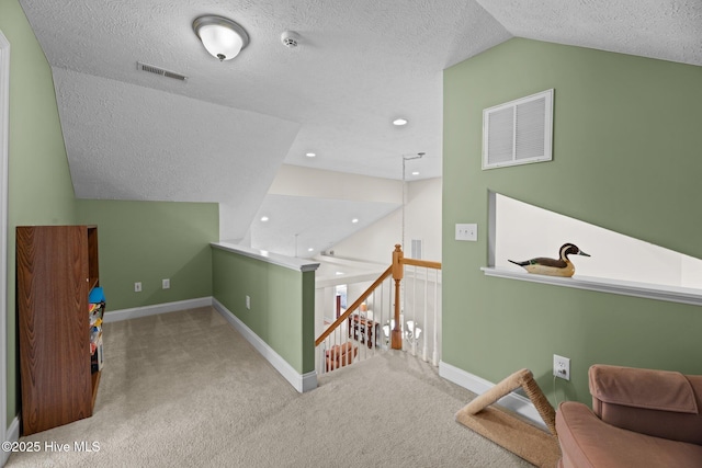 bonus room with light carpet, vaulted ceiling, and a textured ceiling