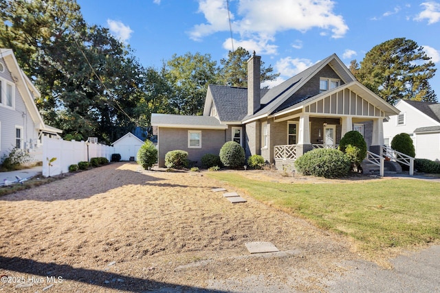 view of front of house with covered porch and a front lawn